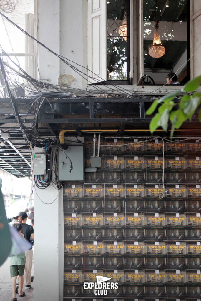 ผนังร้านอี-กา ร้านอาหารไทยริมถนนทรงวาด ถูกบอมด้วยโปสเตอร์ปกหนังสือ SONG WAT GUIDEBOOK โดย Made in Song Wat